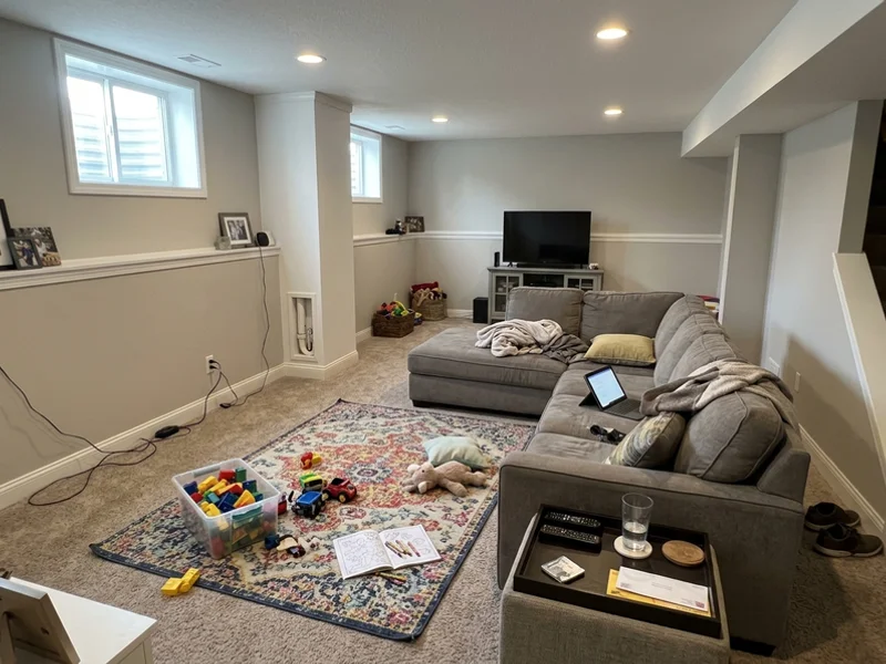 Finished basement family room with a discreet radon pipe in the corner
