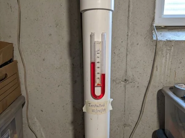 U-tube manometer showing suction on a radon pipe