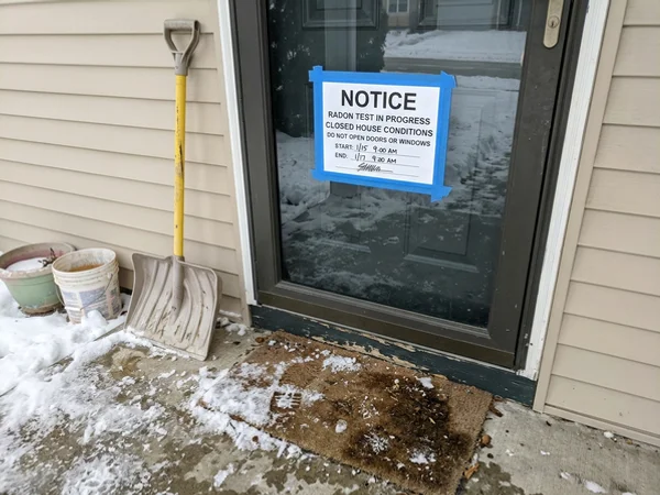 Closed-house conditions notice taped to a front door during a radon test