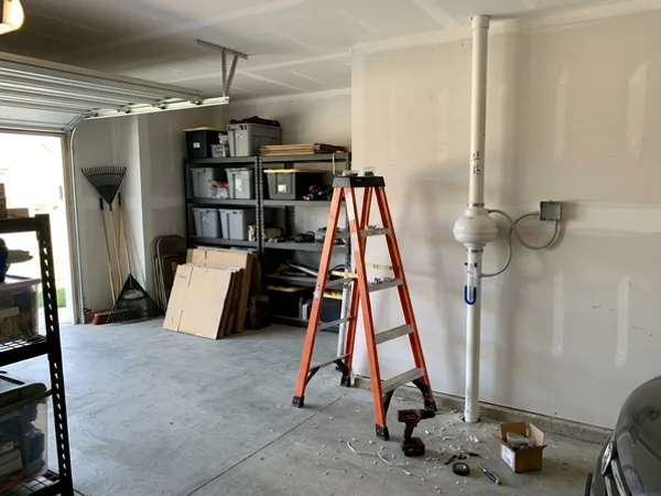 Inline radon fan and manometer added to a passive pipe in a new home garage