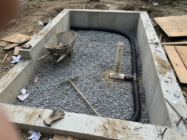 Perforated pipe and suction tee set in gravel before the slab is poured